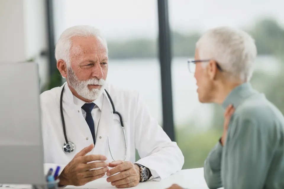 A doctor and a nurse reassuring a senior patient