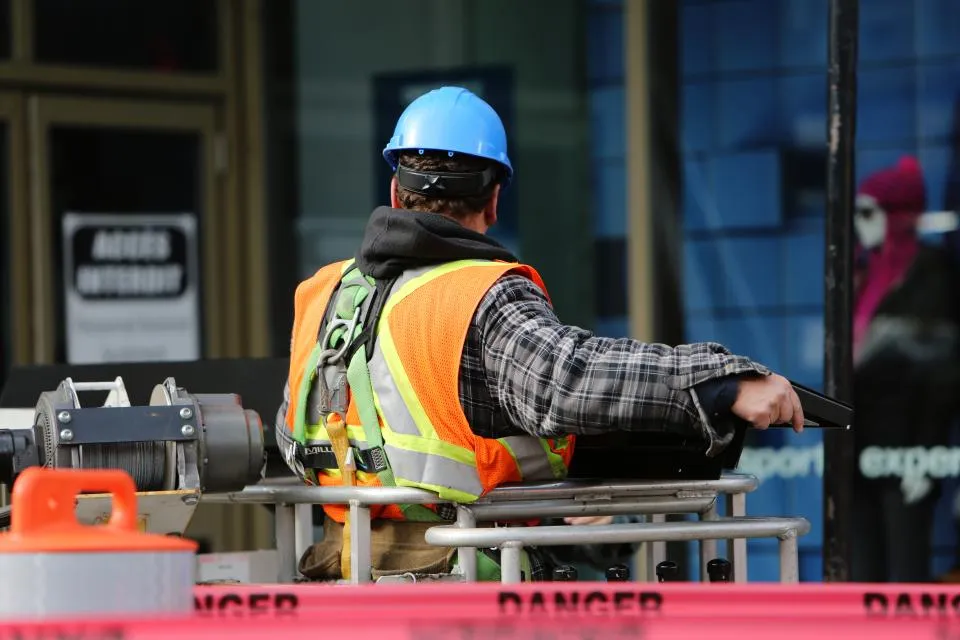 A construction worker in a hard hat and safety vest on the job