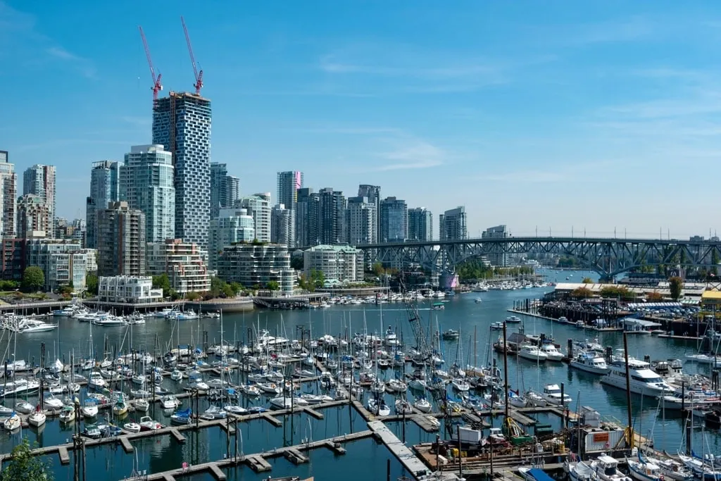 Sailboats in the False Creek marina with the downtown Vancouver skyline on a sunny day